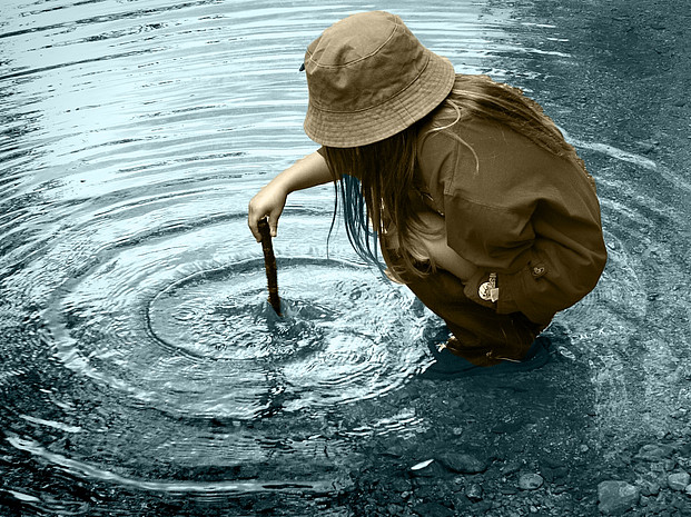 Mädchen spielt am flachen Ufer im Wasser