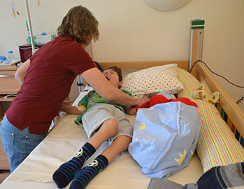 Mutter versorgt liebevoll ihr schwerkrankes Kind